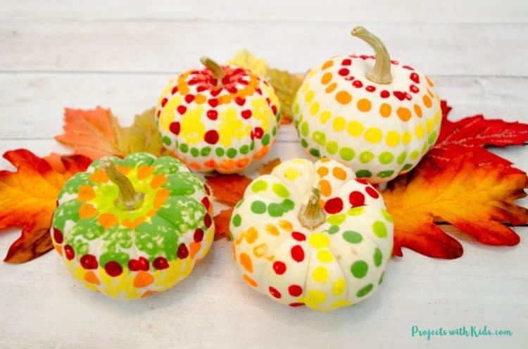 four pumpkins painted with q tips, appears dotted