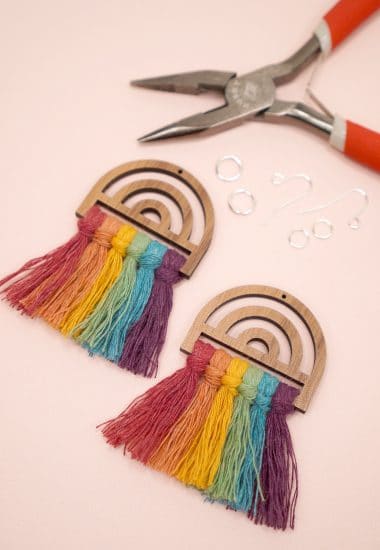 Rainbow macrame frames with earring wires, jump rings, and jewelry pliers in background