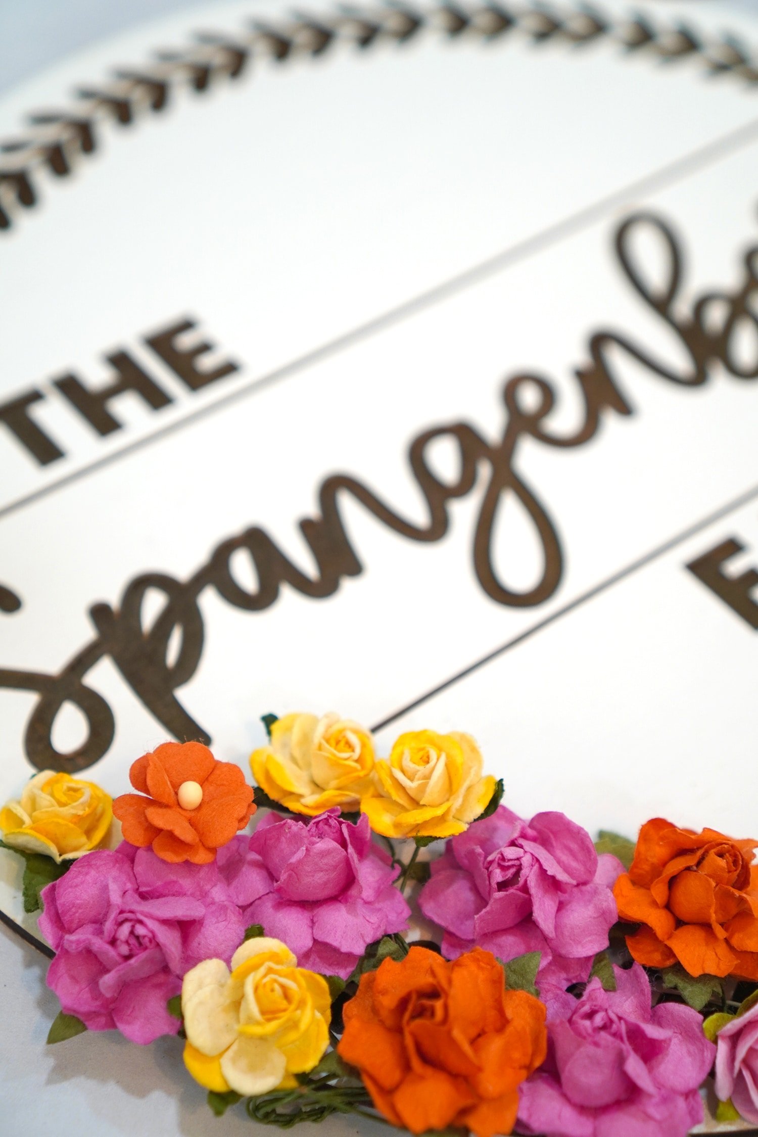 Close up of Adding Faux Flowers to a Glowforge Engraved Family Name Sign