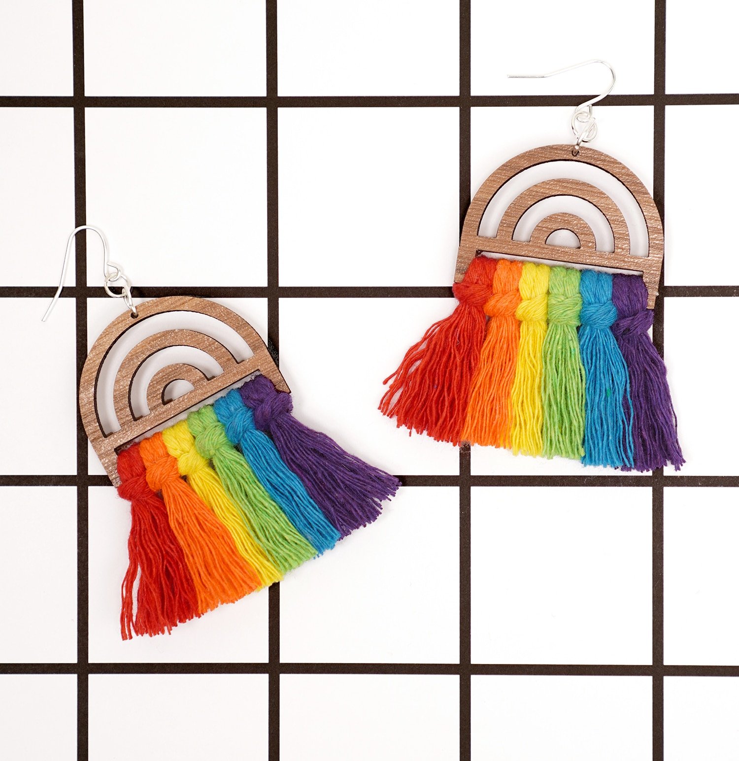 Rainbow macrame earrings on white background with bold black grid lines