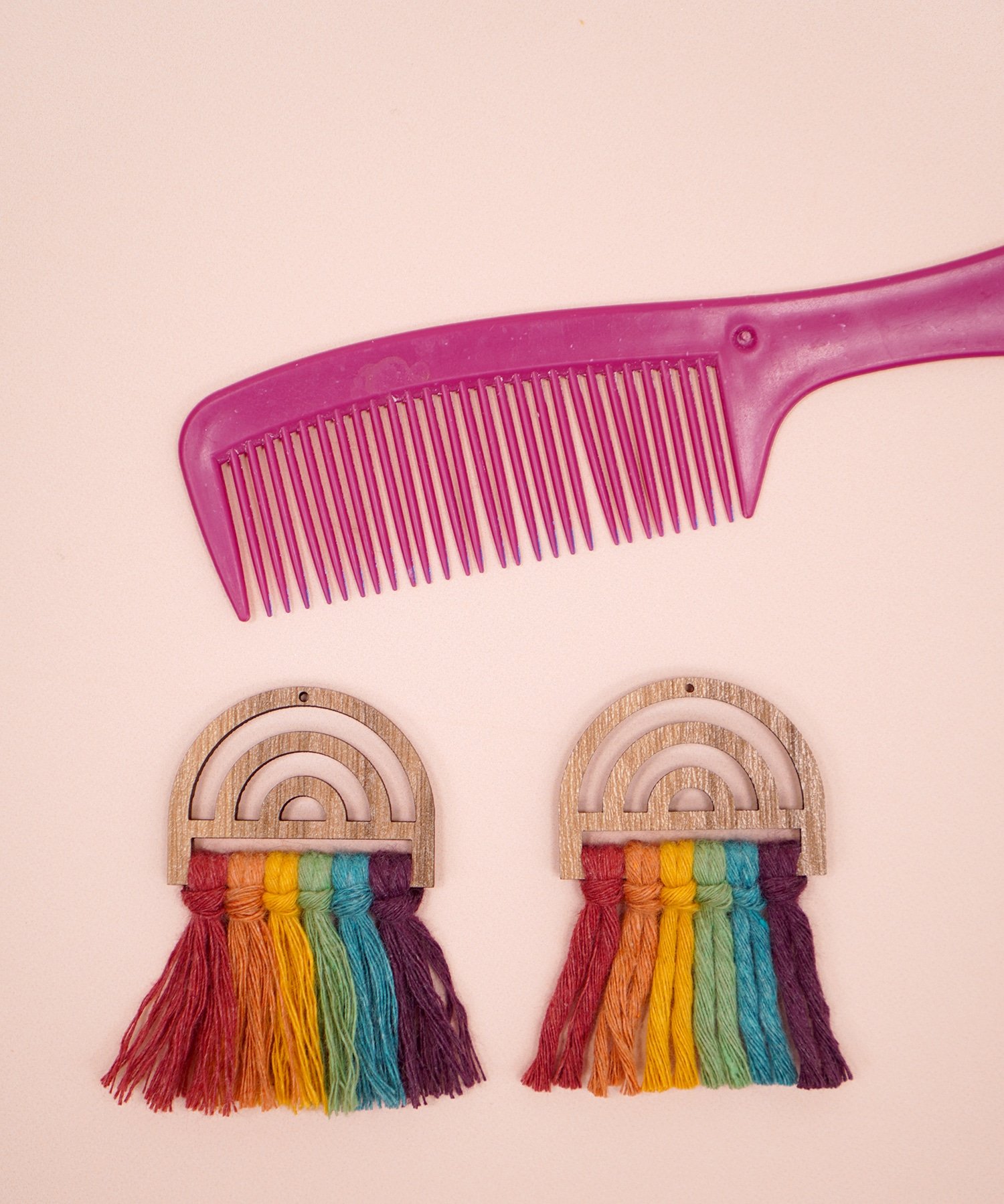 Comparing a brushed vs unbrushed rainbow wooden macrame earring with pink comb in background