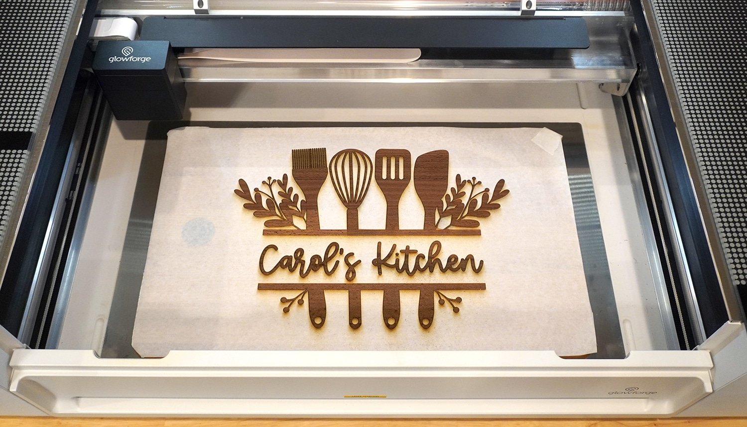 Freshly Engraved "Carol's Kitchen" Cutting Board in Glowforge Pro