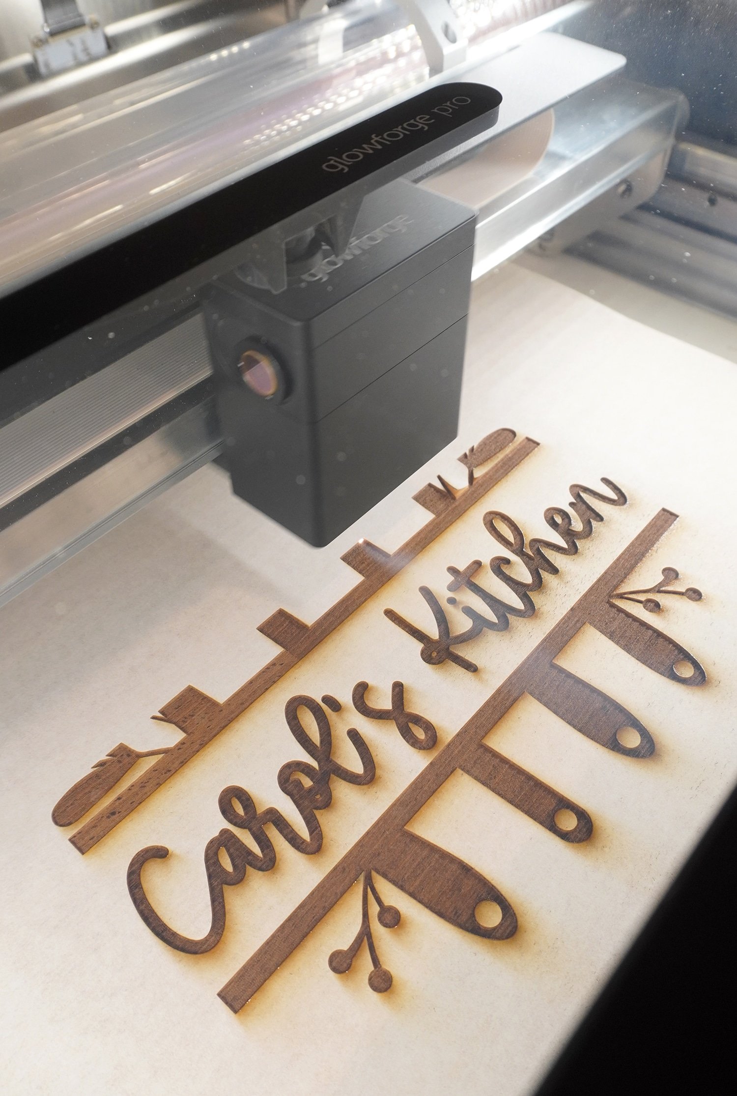 Glowforge Pro Engraving a Cutting Board with "Carol's Kitchen" design