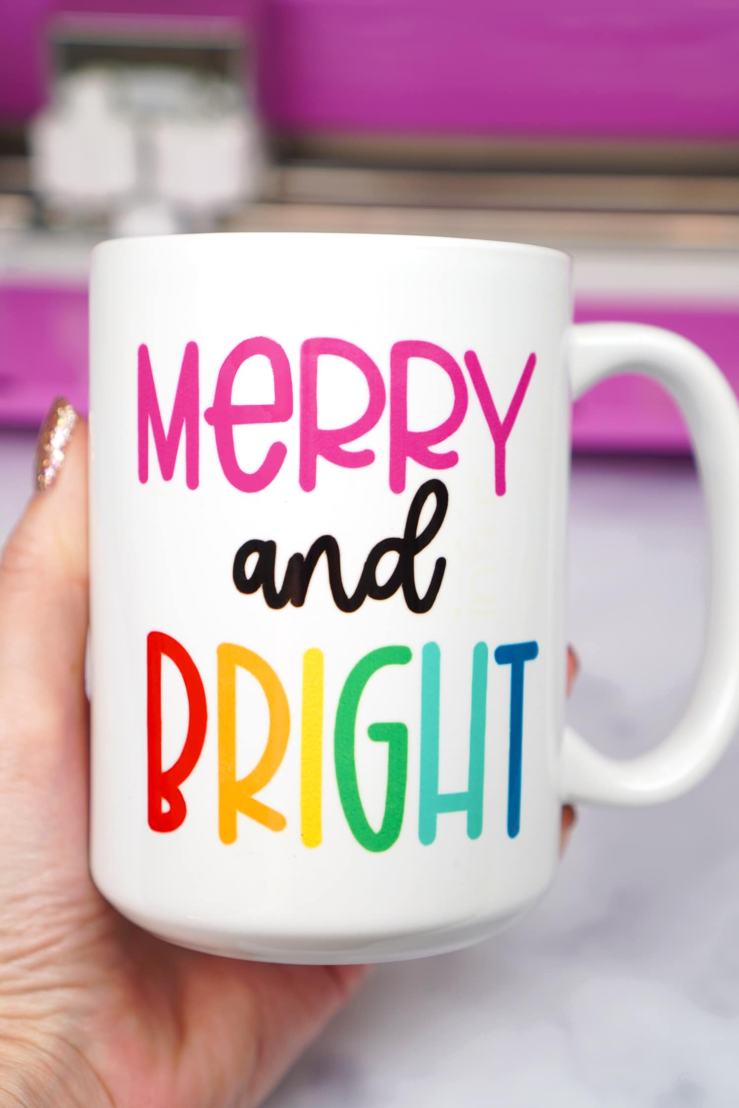 finished mug that reads merry and bright in rainbow and pink fonts