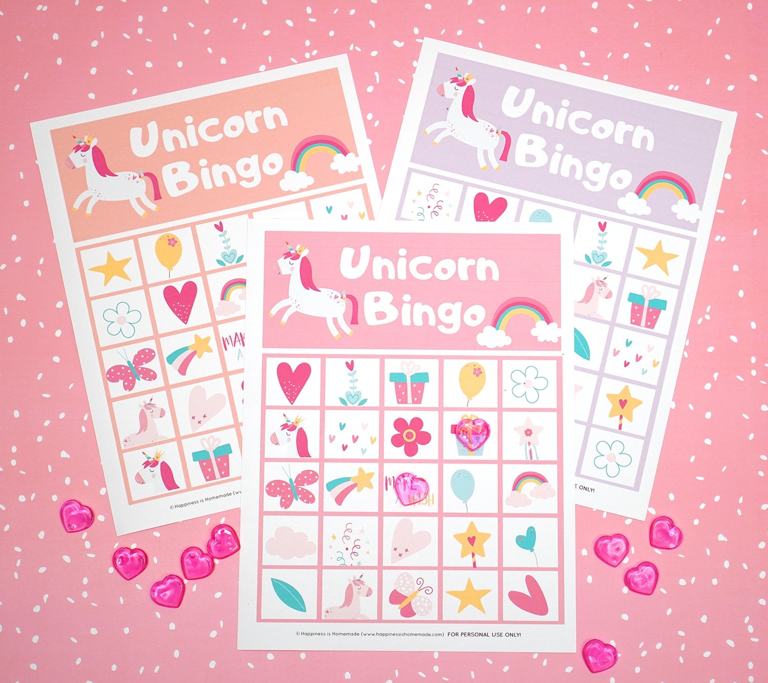 Printable Unicorn Bingo Game Cards on pink background with pink heart markers