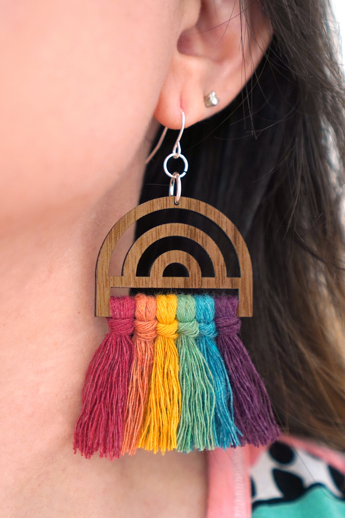 Close up or rainbow macramé earring being worn