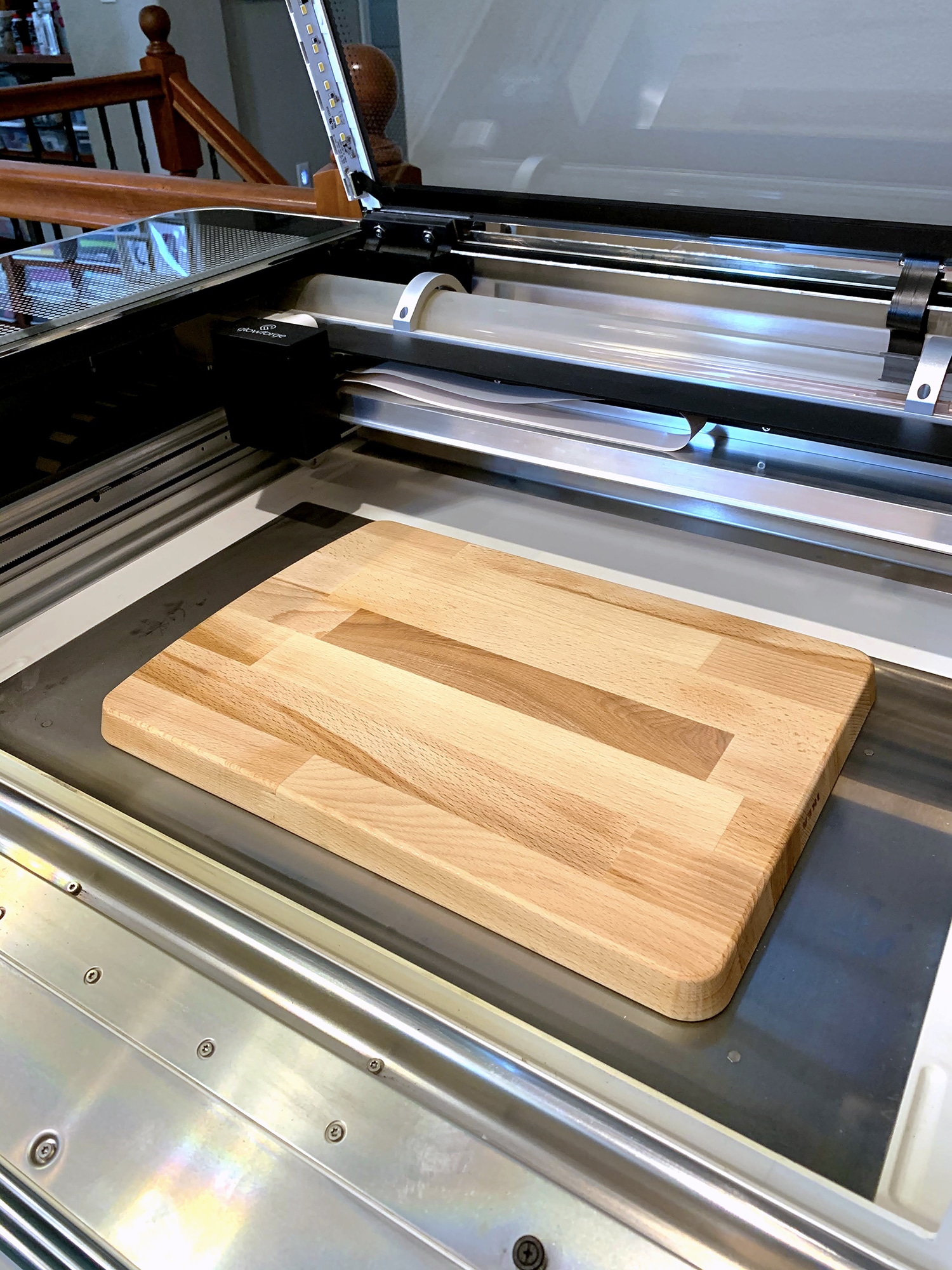 Glowforge machine with front dropped down and cutting board in base of machine