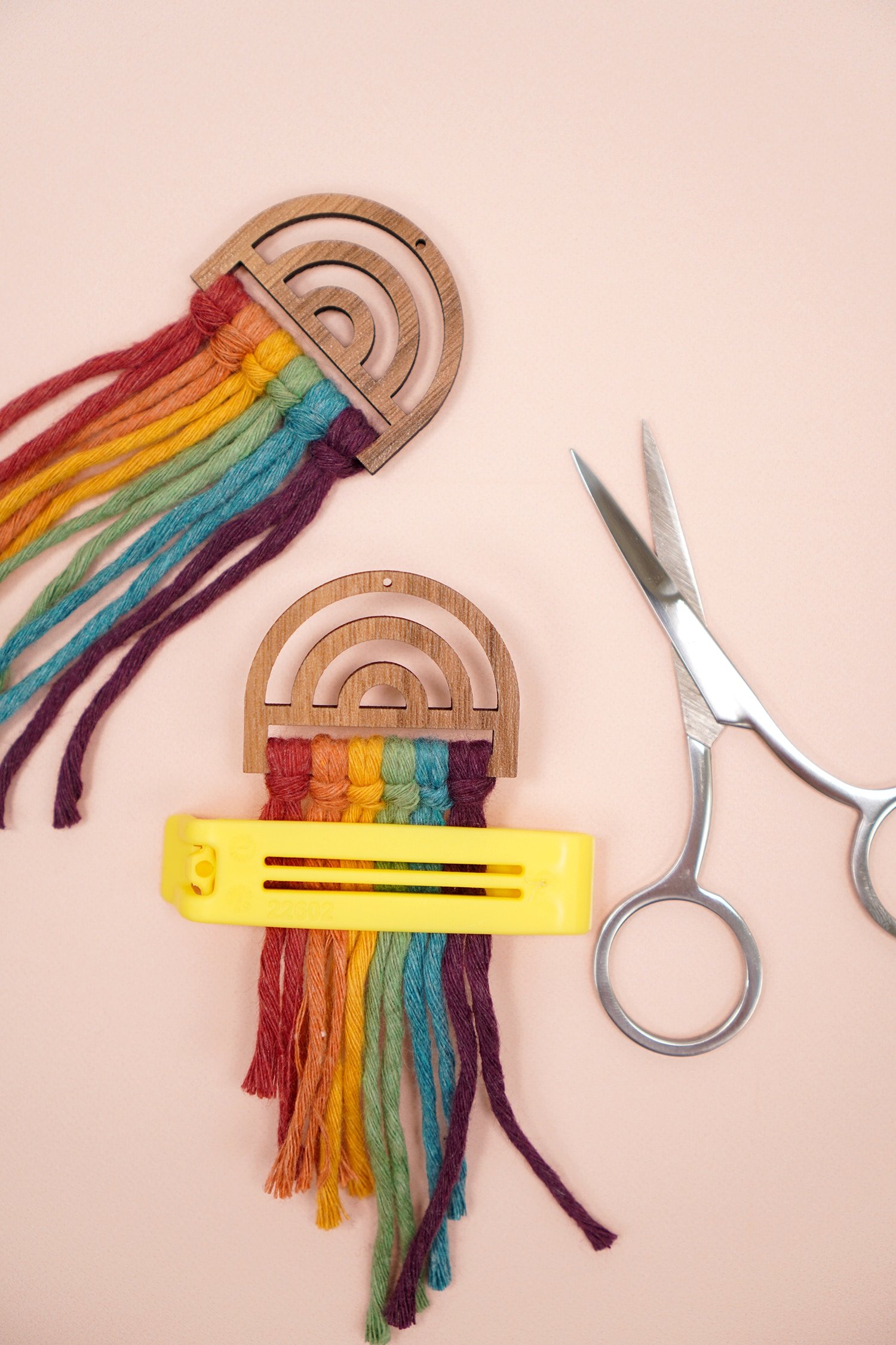 Untrimmed Rainbow Macrame Earrings on peach background with scissors and bag clip