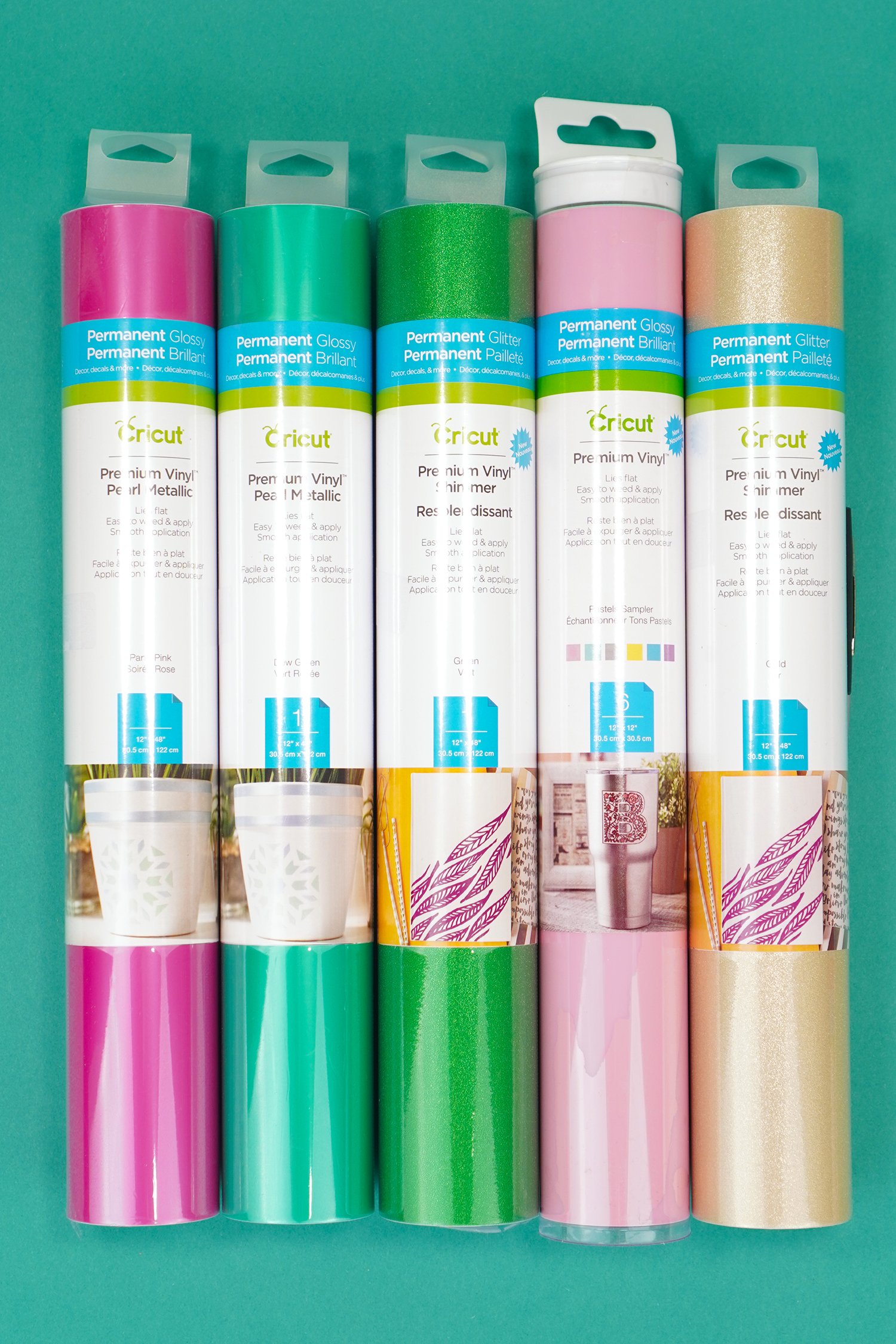 Cricut Vinyl rolls in packaging - pink, teal, green, baby pink, and gold on teal background