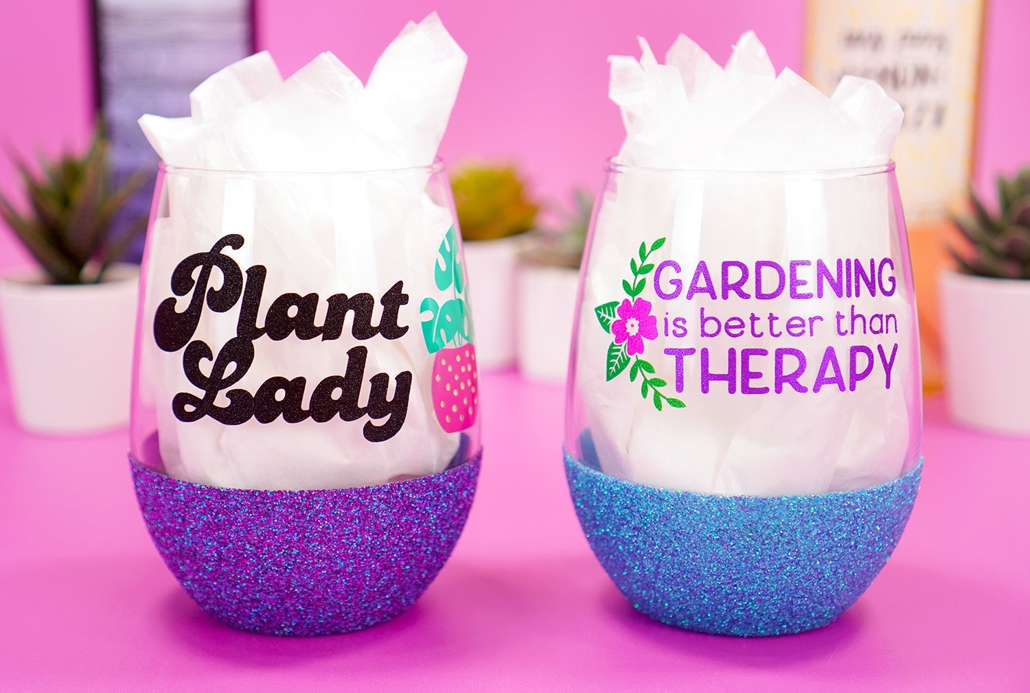 Plant Lady purple glitter wine glass and "Gardening is Better Than Therapy" blue glittered wine glass on purple background with plants