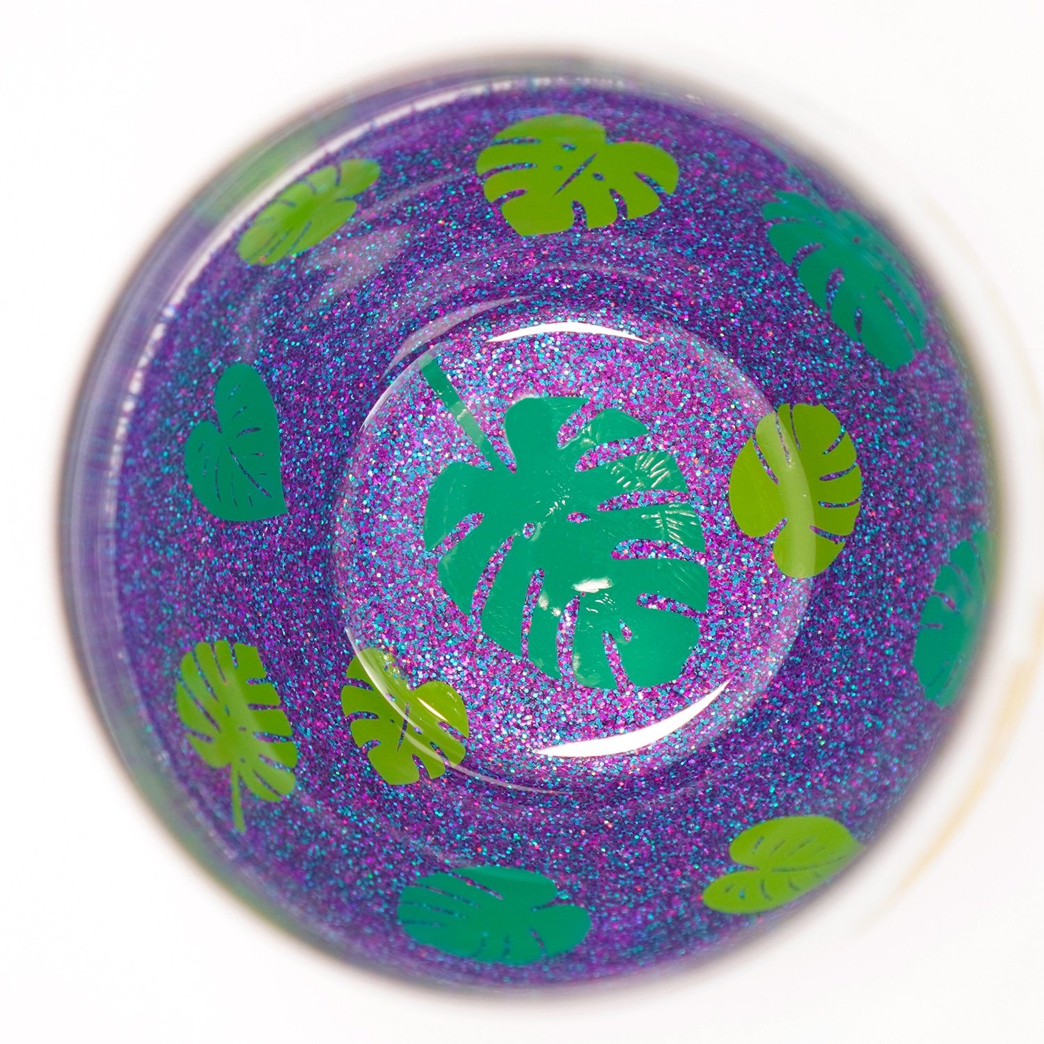 Leaf decals on the inside of a peekaboo glitter wine glass with purple multi-hued glitter