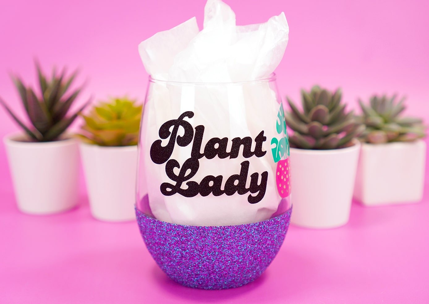 "Plant Lady" glitter wine glass on purple background with plants in background