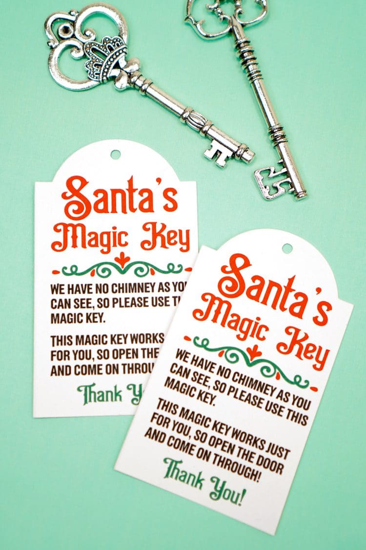 Two Santa's Magic Key printable tags and silver keys on a mint green background