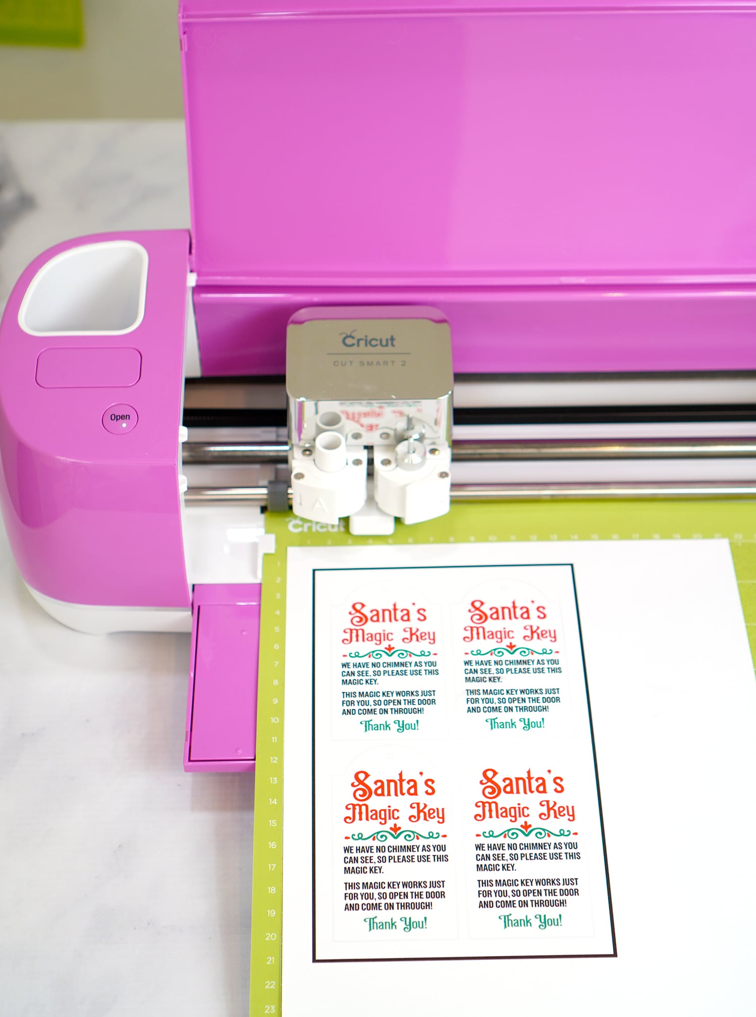 Santa's Magic Key printables on green Cricut mat in fuchsia Cricut Explore machine