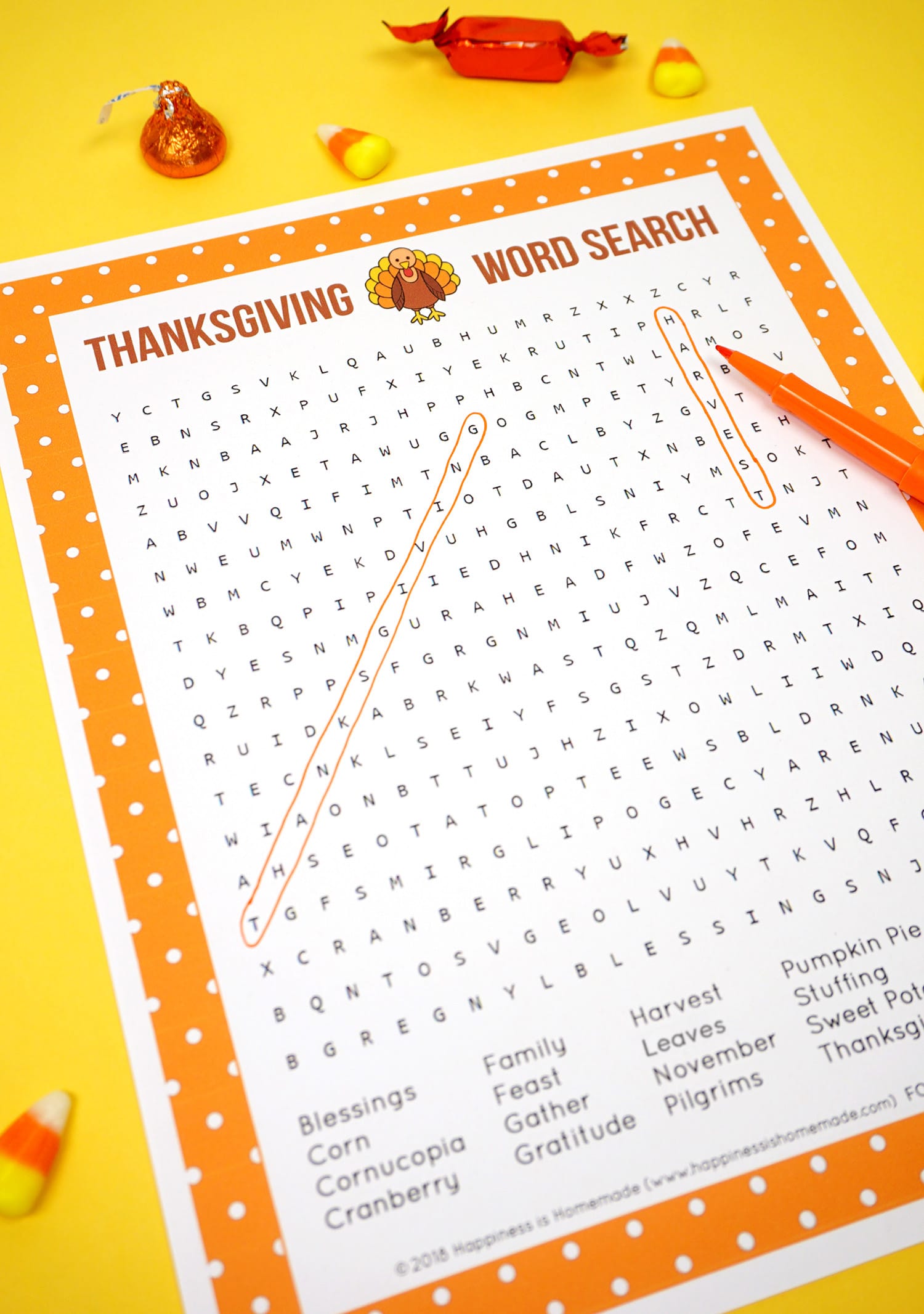 Two Printable Thanksgiving Word Search puzzle game on yellow background with orange pen and candy