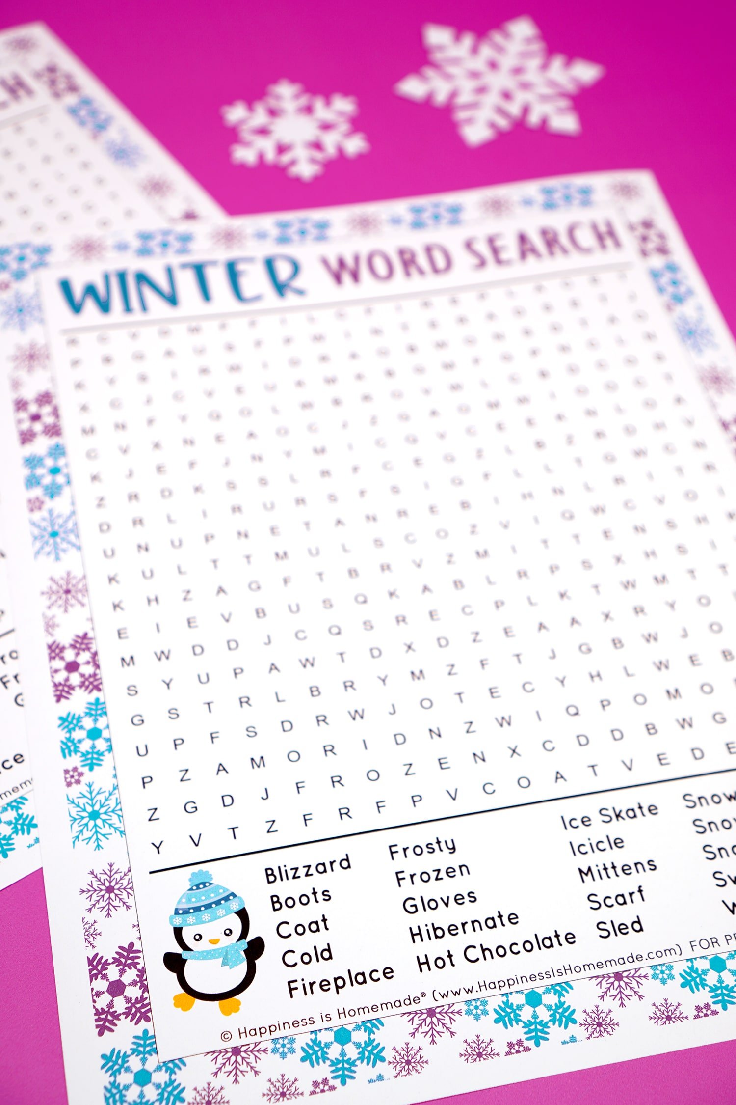Close up of winter word search word list and penguin graphic on a purple background with snowflakes