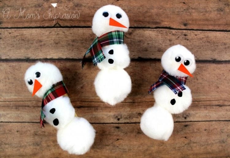 pom pom snowmen on wooden table