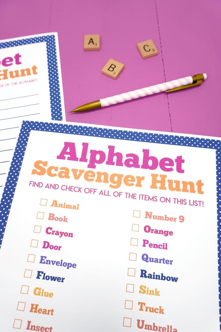 Close up of Alphabet scavenger hunt printable on purple background with pink pencil and ABC alphabet Scrabble tiles