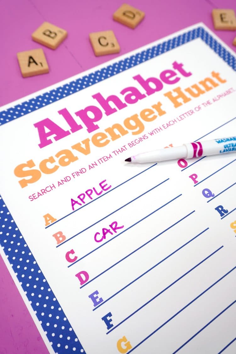 Close up of alphabet scavenger hunt printable on purple background with the words "Apple" and "Car" filled in for letters A and C