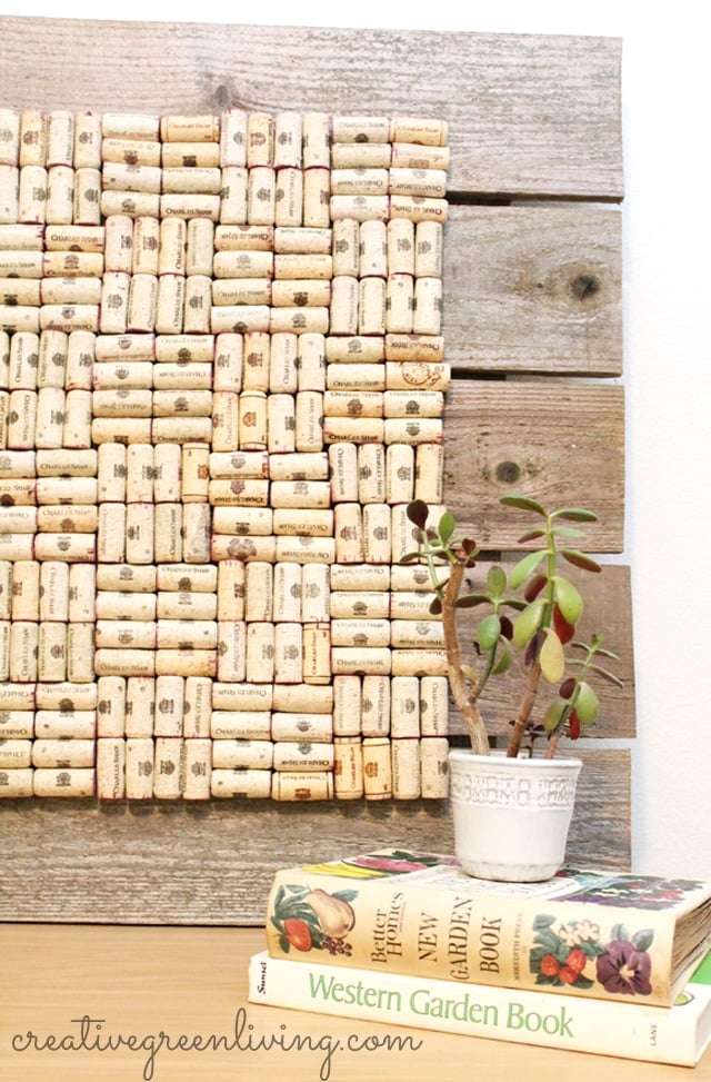 bulletin board made from wine corks next to books and a plant