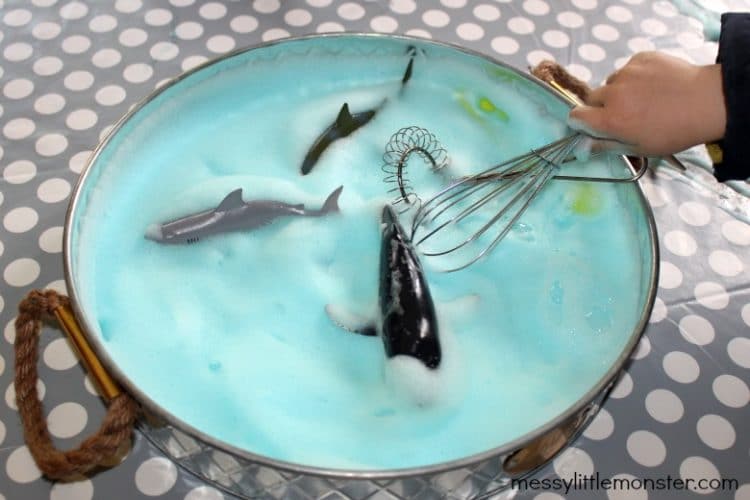ocean sensory bin being played with a whisk