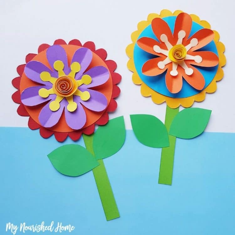 two whimsical colorful paper flowers on wall