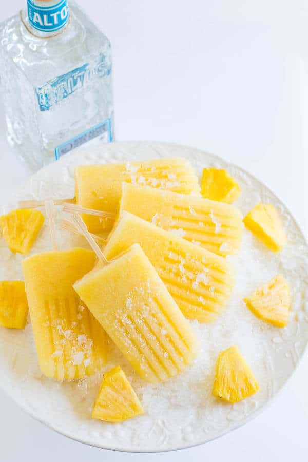 boozy pineapple ice pops with pineapple chunks
