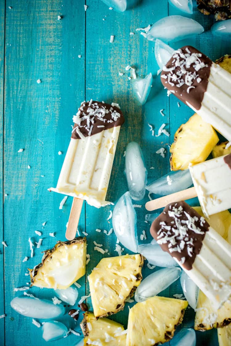 easy chocolate pina colade popsicles on blue background with ice