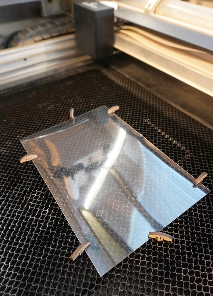 glowforge machine with acetate hold down pins on project