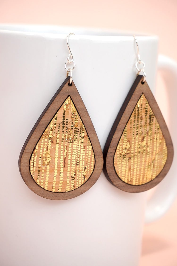 Close up of gold dotted cork and laser cut wood earrings