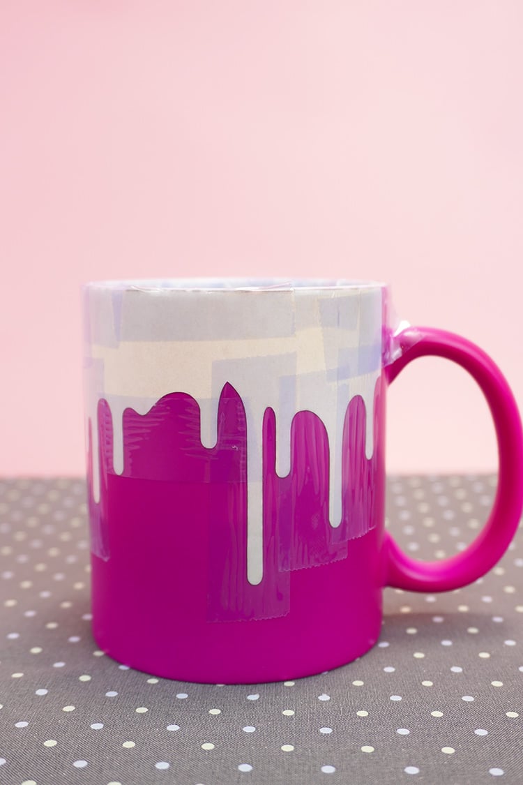 Bright pink mug with "Drippy" Infusible Ink design cooling on a polka dot mat