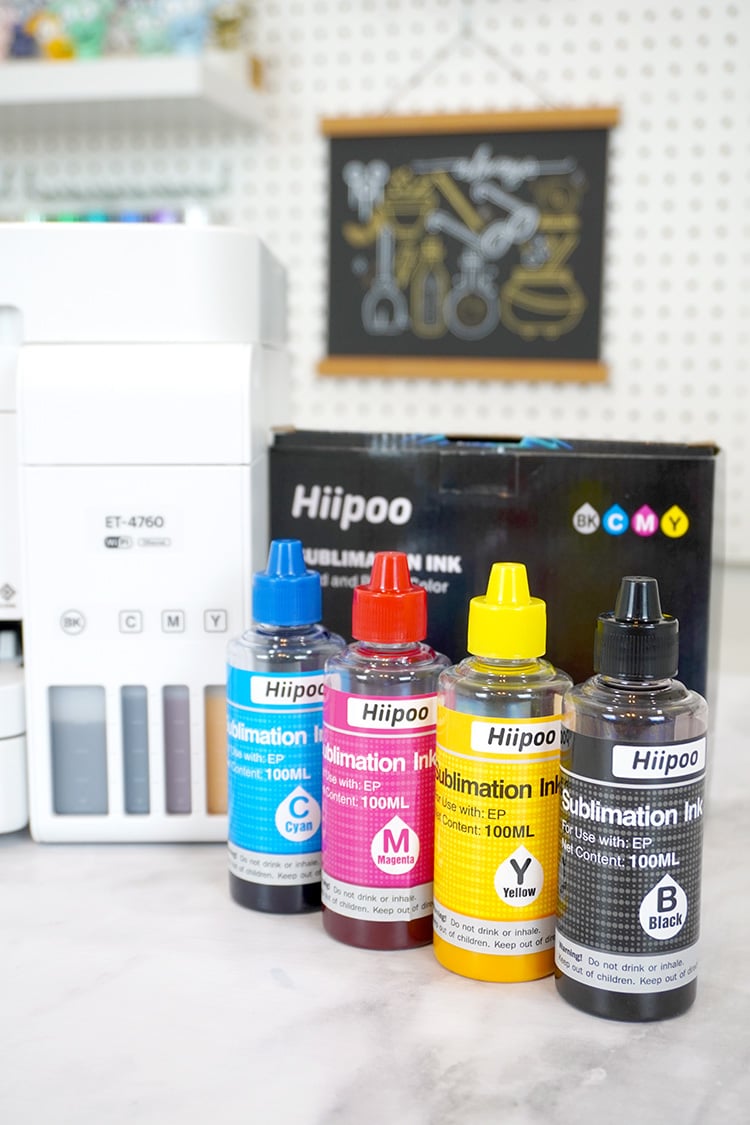 4 bottles of Hiipoo sublimation ink in cyan, magenta, yellow, and black in front of Epson EcoTank printer