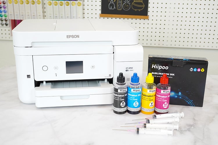 Supplies on desktop for converting an EcoTank printer to a sublimation printer - ink, printer, syringes