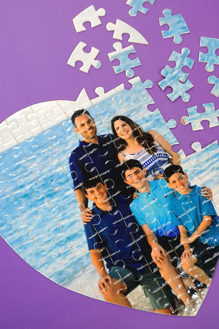Close up of partially aseembled custom photo puzzle on purple background