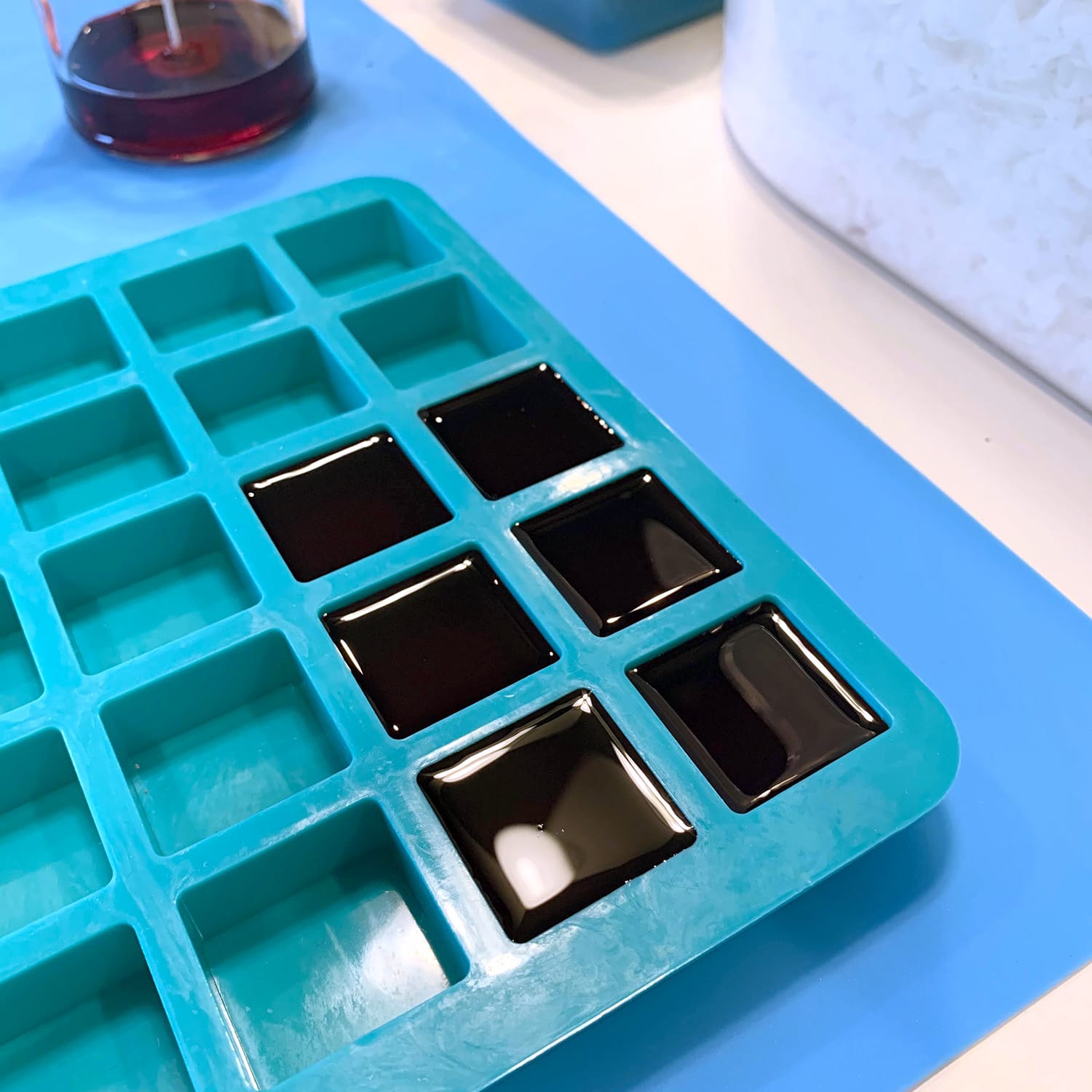 Freshly poured red wax cubes in silicone tray