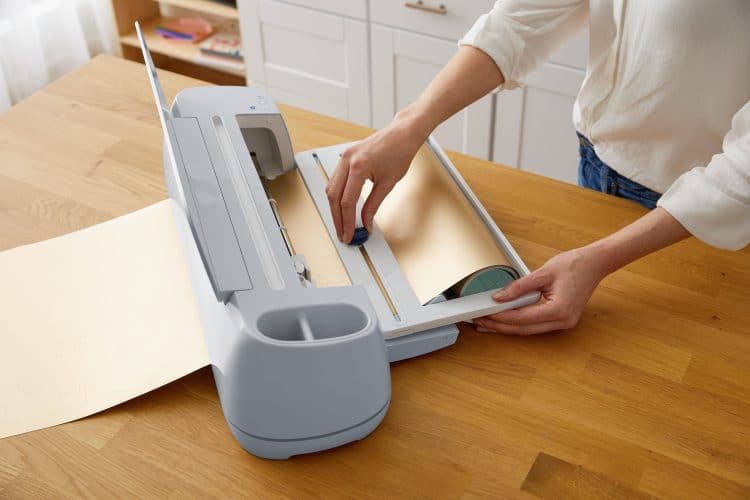 woman scoring cricut material in cricut machine