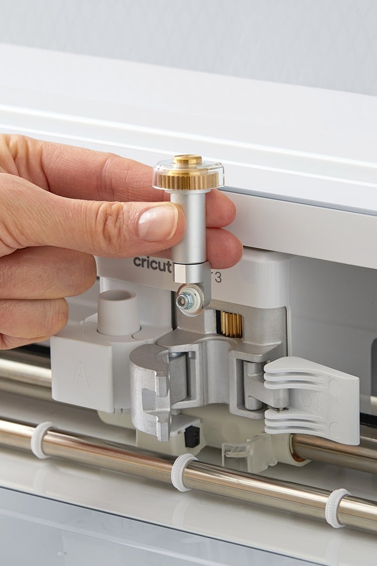Hand inserting rotary blade into the Cricut Maker 3 tool carrier system