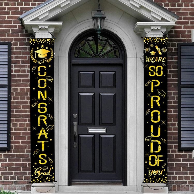 Two black banners with gold lettering in front of house