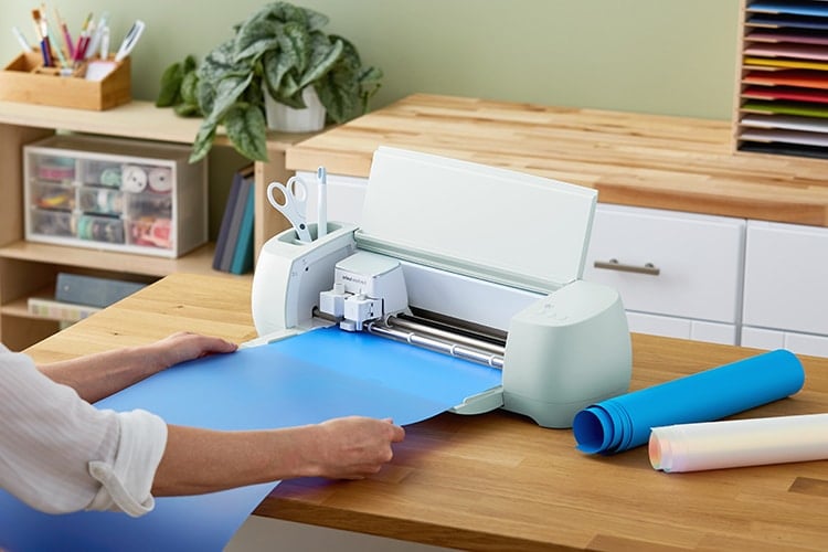 Feeding blue Smart Iron-On into Cricut Explore 3