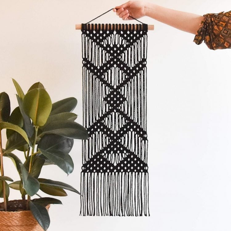 woman holding black macrame pattern up