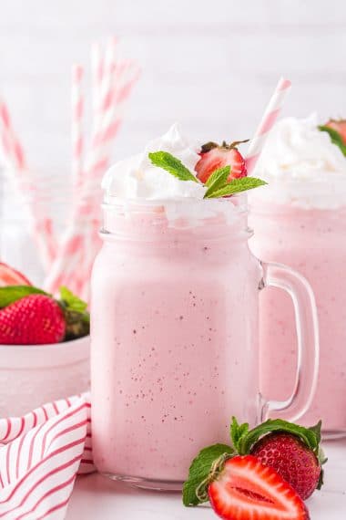 Strawberry milkshake with whipped cream and strawberry garnish