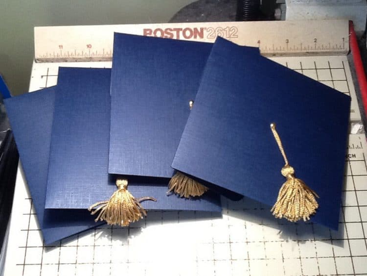 Blue graduation cap shaped invitations with gold tassle