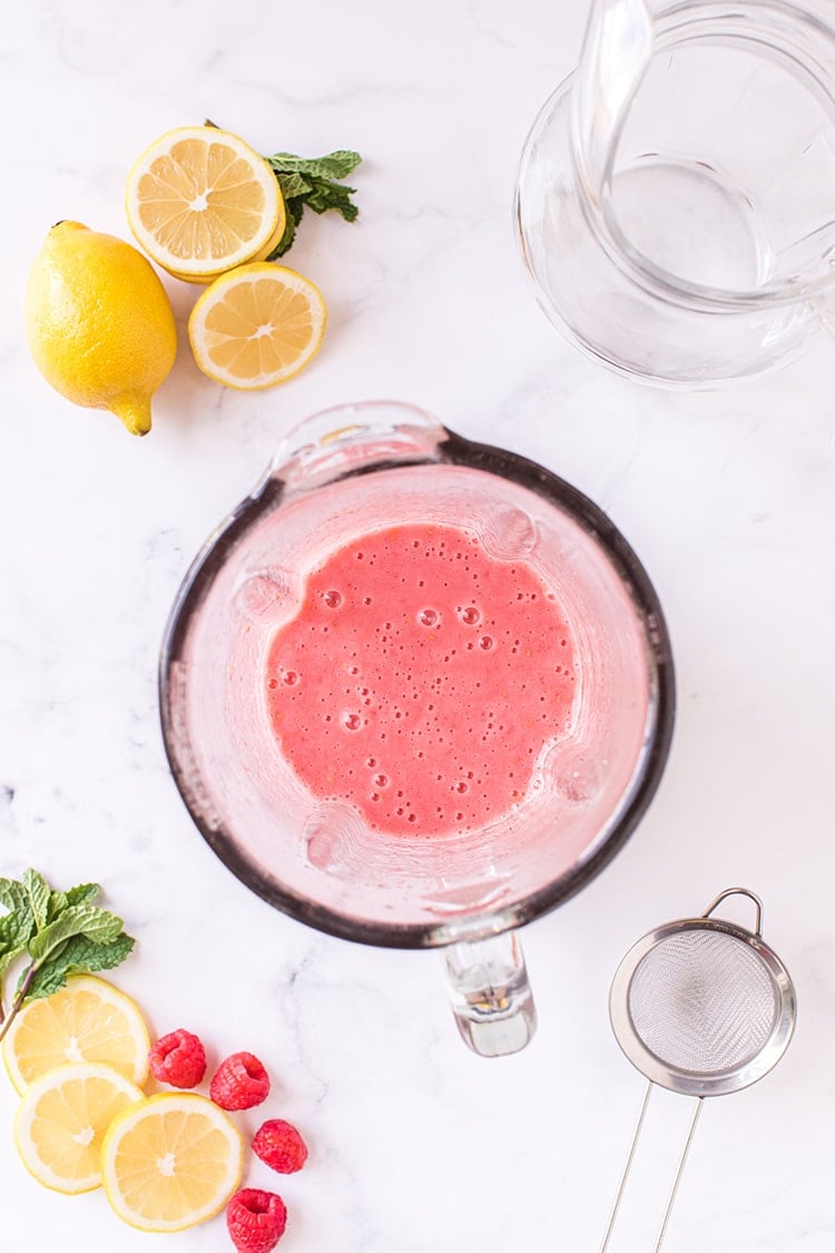freshly blended raspberry puree with lemonade in blender