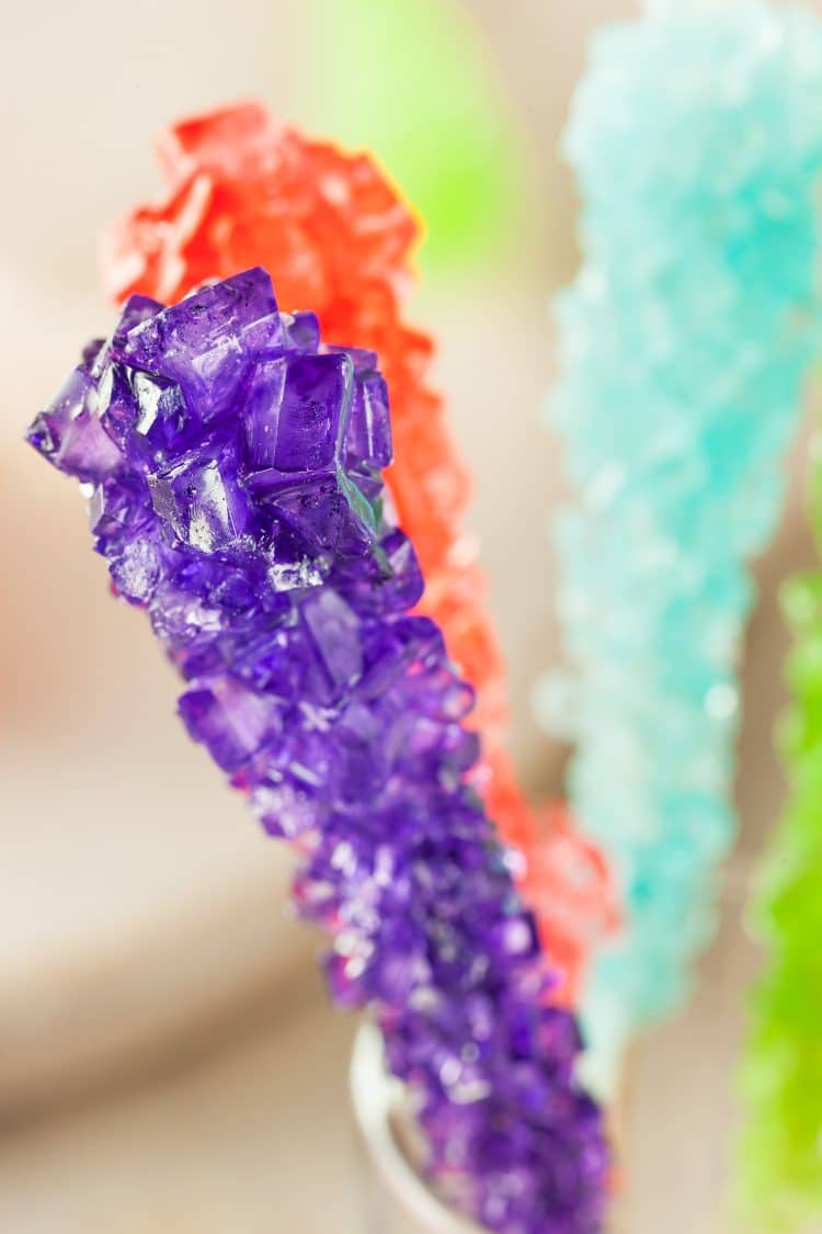 Close up view of purple rock candy with other colors of rock candy in the background
