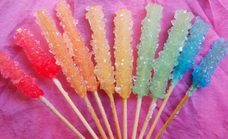 rainbow of homemade rock candy on purple background