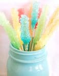 colorful rock candy sticks in an aqua mason jar