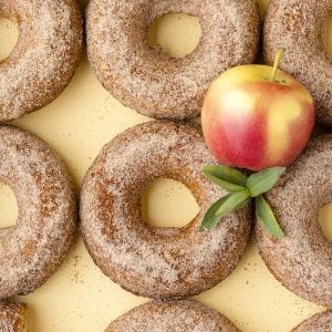 apple cider donuts with apples on yellow background