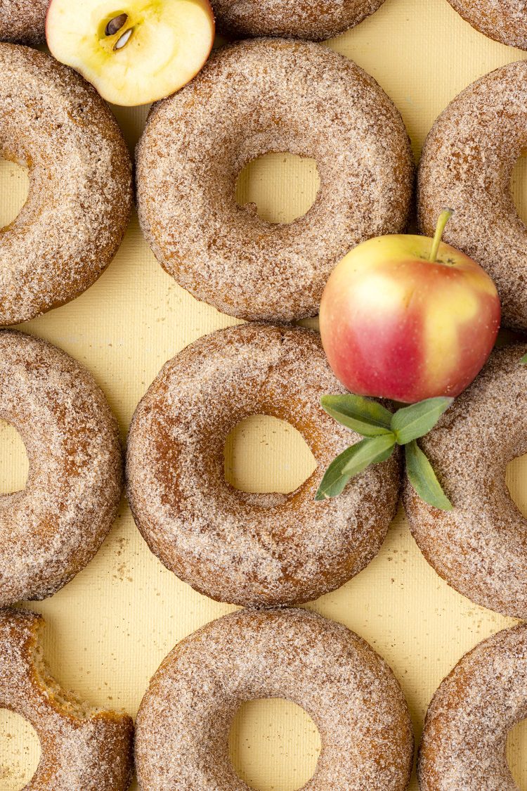 apple cider donuts with apples on yellow background