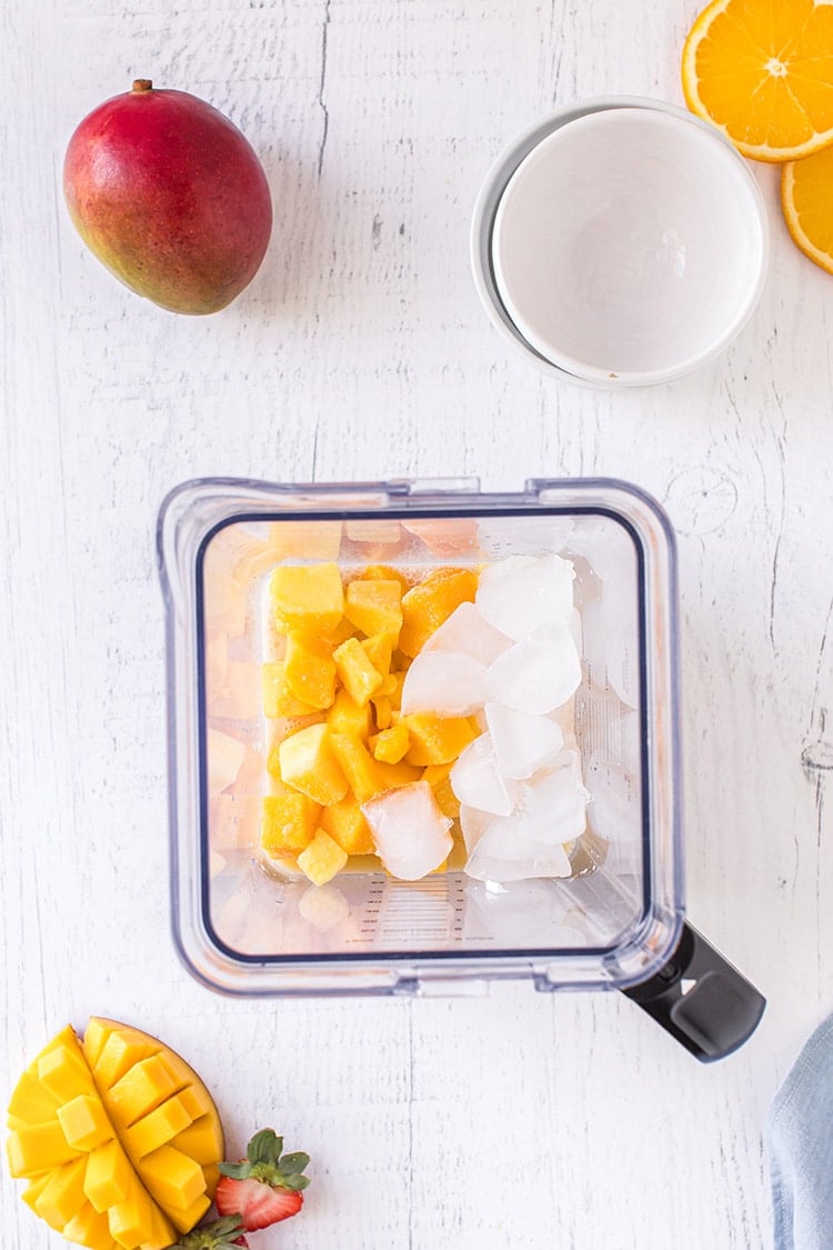Overhead shot of mango smoothie recipe ingredients in a blender