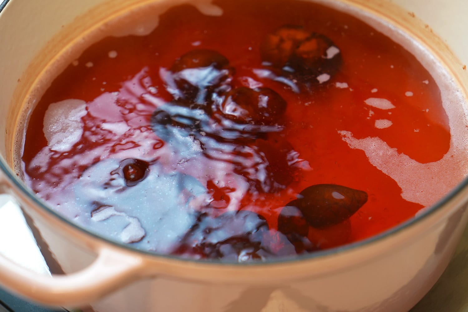 Close up of avocado dye simmering in pot with avocado pits